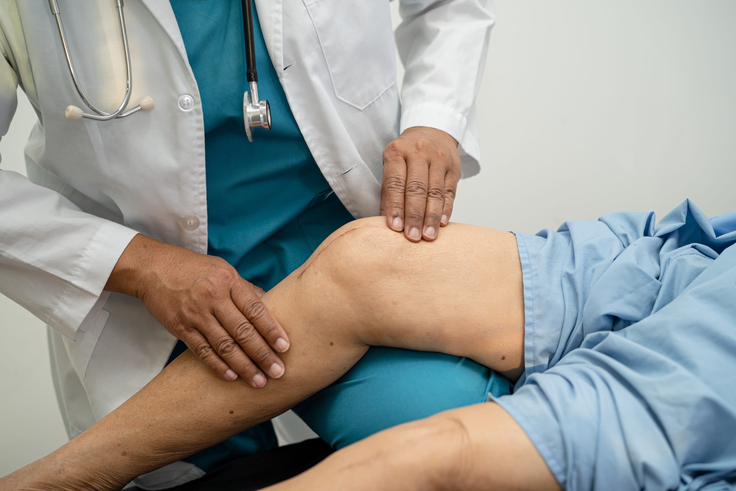 Clinician hands assessing a bent knee